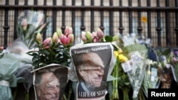 Foto Pangeran Philip, suami Ratu Elizabeth, terlihat di koran-koran yang dibungkus bunga, setelah ia meninggal pada usia 99 tahun, di London, Inggris, 9 April 2021. (Foto: Reuters)