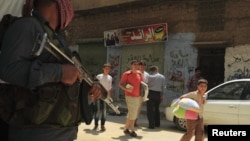 Warga Salah Edinne, Aleppo, bergegas meninggalkan tempat tinggalnya melintasi tentara Pembebasan Suriah yang tengah berjaga di tengah berkecamuknya pertempuran dengan pasukan pemerintah di kota itu (31/7). Pemerintah AS mengecam perintah presiden Assad un