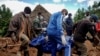 Men retrieve the body of a teenager killed by mudslides triggered by Cyclone Idai, in Chimanimani, Zimbabwe, March 22, 2019. Hardest-hit Mozambique increased its death toll from the powerful storm to 493.