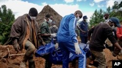 Men retrieve the body of a teenager killed by mudslides triggered by Cyclone Idai, in Chimanimani, Zimbabwe, March 22, 2019. Hardest-hit Mozambique increased its death toll from the powerful storm to 493.