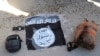 FILE - An Islamic State flag and other possessions from IS group fighters are seen in Hassakeh, Syria, Jan. 21, 2022. 