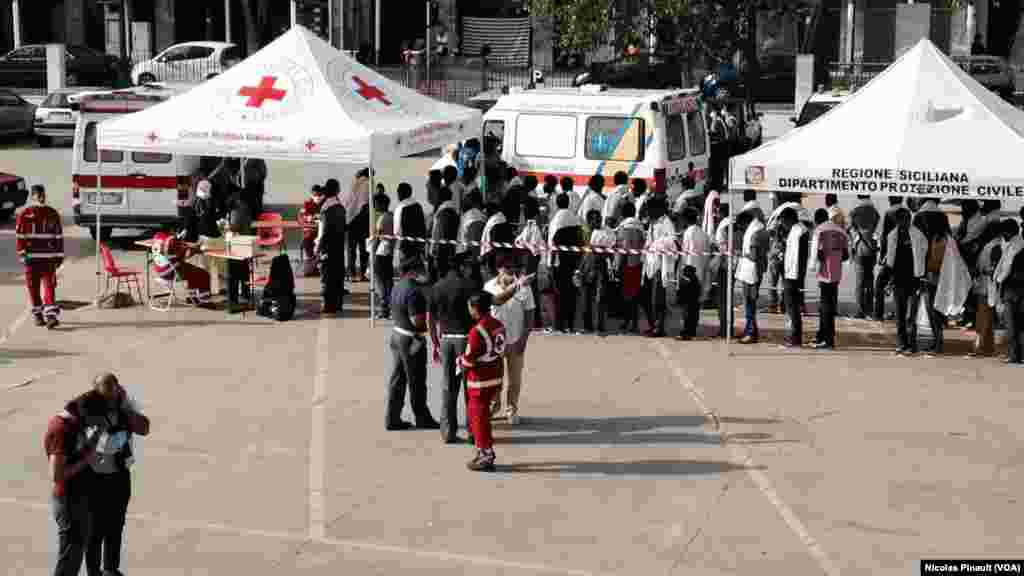 File d&#39;attente des des migrants avant de passer dans un centre médical de la CRoix Rouge italienne à Messine, Sicile, 6 octobre 2015 (Nicolas Pinault/VOA).