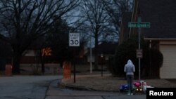 A person pays their respects as balloons, notes, candles, stuffed animals, flowers and other offerings are visible at the site where Tyre Nichols was severely beaten by Memphis police officers in Memphis, Tennessee, Jan. 28, 2023.