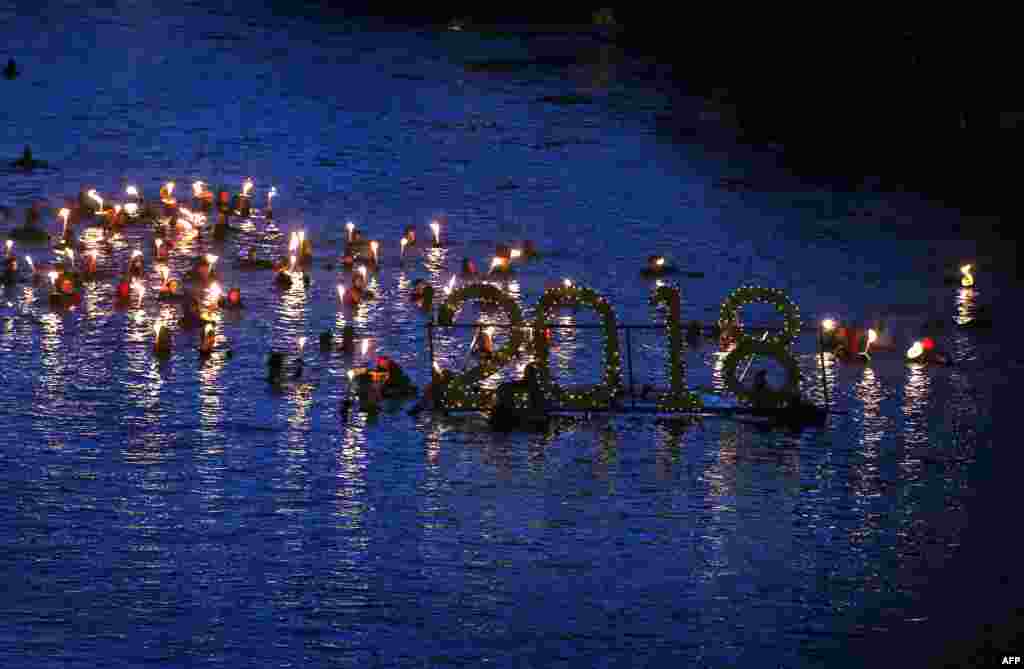 2018年1月1日，德国南部的菲森，救生员在莱希河的冷水中洗澡，以传统的冬泳活动迎接新年。