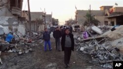 Penduduk setempat meneliti kerusakan rumah-rumah setelah serangan bom mobil di Kirkuk, Baghdad (17/12). (AP/Emad Matti)