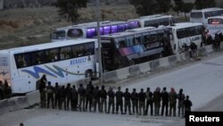 Para tentara pemberontak berdoa sebelum mereka dievakuasi keluar Harasta di timur Ghouta, di Damakcus, Suriah, 23 Maret 2018. 