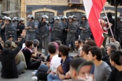 Police stand guard as anti-government protesters block a main highway in Beirut, Lebanon, Nov. 4, 2019.