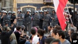 Police stand guard as anti-government protesters block a main highway in Beirut, Lebanon, Nov. 4, 2019.