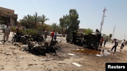 People gather at the site of a car bomb attack in Baghdad, Aug. 15, 2013.