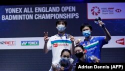 Pemenang ganda campuran turnamen All England Yuta Watanabe (kanan) dan Arisa Higashino (kanan) berpose di podium bersama juara dua, Yuki Kaneko (kiri (belakang) dan Misaki Matsumoto (kiri depan), di Arena Utilita, Birmingham, Minggu, 21 Maret 2021.