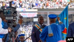 A Constitutional Court judge hands the national flag to Congolese President Felix Tshisekedi after he took the oath of office at his inauguration ceremony in Kinshasa on Jan. 20, 2024.