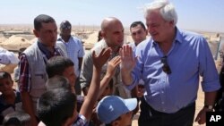 U.N. Under-Secretary-General for Humanitarian Affairs, Stephen O'Brien, greets Syrian refugees who fled civil war in their country, in the Zaatari Refugee Camp, near Mafraq, Jordan.