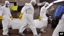 Children watch as health workers remove the body of a suspected Ebola victim in an area known as Clara Town in Monrovia, Liberia, Sept. 10, 2014. 