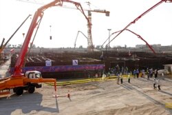 In this photo by the Atomic Energy Organization of Iran, concrete is poured for the base of the second nuclear power reactor at Bushehr plant, Nov. 10, 2019.