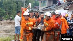 Des pompiers portent sur une civière un blessé après le séisme dans le village Gengdi, à Sichuan, Chine 8 août 2017.