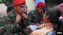 Seorang tenga medis Kopassus sedang memeriksa Ibu dan seorang anaknya yang sedang sakit di salah satu tempat penampungan korban Merapi.