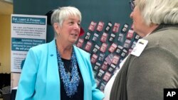 Independent gubernatorial candidate and Maine State Treasurer Terry Hayes speaks with a supporter at a gubernatorial forum, Oct. 4, 2018, in Waterville, Maine.