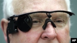 Seorang pasien di Coventry, Inggris, menggunakan kacamata yang dilengkapi dengan kamera yang berfungsi untuk merekam gambar yang dikirimkan ke retina buatan (Argus II) yang dicangkok di mata kanannya (Foto: dok). FDA telah memberikan ijin untuk penggunaan Argus II di Amerika.