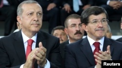 Turkish president-elect Tayyip Erdogan (L) and incoming prime minister Ahmet Davutoglu applaud during the Extraordinary Congress of the ruling AK Party (AKP) in Ankara, Aug. 27, 2014. 