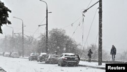 2024年1月8日，调查人员在乌克兰扎波罗热俄罗斯导弹袭击现场的受损汽车旁工作。（路透社照片）