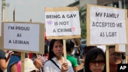 FILE - Indonesian gay activists hold posters during a protest demanding equality for LGBT (Lesbian, gay, bisexual and transgender) people in Jakarta, Indonesia, Saturday, May 21, 2011. Being gay or lesbian has never been outlawed in Indonesia, except in the province of Aceh.
