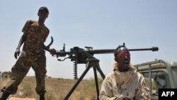 FILE - Somali government soldiers looking out from a machine gun mounted pick-up truck at Tobanka Buundo in the lower Shabelle region, near the Somalian capital Mogadishu, March 6, 2014.