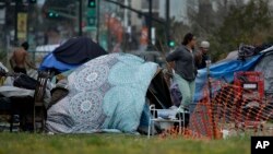 មនុស្ស​នៅកន្លែង​សម្រាប់​អ្នក​គ្មាន​ទីជម្រក​នៅ​រដ្ឋ​កាលីហ្វ័រញ៉ា កាល​ពី​ថ្ងៃ​ទី​១៩ មីនា ២០២០។ អភិបាល​រដ្ឋ លោក Gavin Newsom បាន​បញ្ចេញ​ប្រាក់​១៥០​លាន​ដុល្លារ​សម្រាប់​មនុស្ស​គ្មាន​ទីជម្រក នៅ​រដ្ឋ​នេះ នៅ​ពេល​វីរុស​កូរ៉ូណា​កំពុង​រីក​រាល​ដាល។