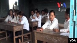 កុមារក្រី​ក្រ​ អង្គុយ​​នៅ​ក្នុង​ថ្នាក់​រៀន​​នៅ​​ក្នុង​ភូមិ​អណ្តែត​ទឹក​មួយ​នៅ​លើ​បឹង​ទន្លេសាប​ក្នុង​ប្រទេស​កម្ពុជា​។