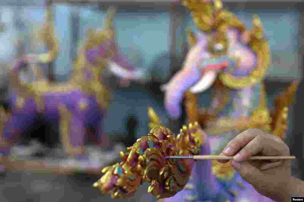An artist works on a deity sculpture that will decorate the funeral pyre of the late King Bhumibol Adulyadej, near the Grand Palace in Bangkok, Thailand, Sept. 8, 2017.