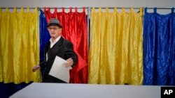 A man exits the voting booth, in Bucharest, Romania, Saturday, Oct. 6, 2018. Two days of voting on a constitutional amendment that would make it harder to legalize same-sex marriage has started in Romania.