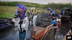 Des déplacés débarquent d'une barge accosté au (fleuve) Nil Blanc, dans la ville de Awerial, le Sud-Soudan. 