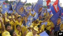 Supporters royalist party Funcinpec hold their party flags and national flags during the last day of national election campaign in Phnom Penh, file photo. 