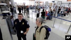 U.S. Customs and Border Protection supervisor Erik Gordon, left, helps a passenger at a new facial recognition kiosks before boarding a flight to Tokyo, Wednesday, July 12, 2017, at George Bush Intercontinental Airport, in Houston. (AP Photo/David J. Phillip)
