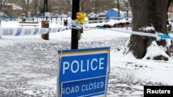 Flowers are left at the cordon near the tent covering the park bench where former Russian intelligence officer Sergei Skripal and his daughter Yulia were found poisoned in Salisbury, Britain, March 19, 2018. 