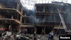 3일 바그다드 카라다 상업지구의 폭탄 테러 현장에 사람들이 모여 있다.