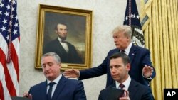 President Donald Trump, walks to acting Department of Homeland Security Secretary Kevin McAleenan, seated right, and Guatemalan Interior Minister Enrique Degenhart in the Oval Office of the White House, July 26, 2019. 