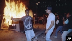FILE - Demonstrators protest the verdict in the Rodney King beating case in front of the Los Angeles Police Department headquarters, April 29, 1992, in Los Angeles.