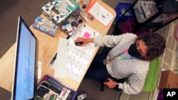 Art teacher Sarah Hager works at a computer in her classroom at Cleveland Middle School on Sunday, Jan. 23, 2022, in Albuquerque, N.M. Public school systems.