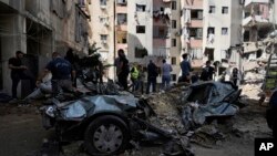 Emergency workers clear the rubble at the site of an Israeli strike in a suburb of Beirut, Lebanon, Sept. 22, 2024.