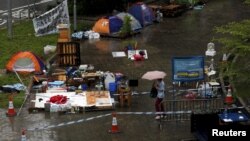A passerby walks past tents, before they are removed, outside the government headquarters in Hong Kong, China, June 24, 2015.