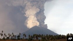 Gunung Agung terus menyemburkan abu dan asap yang tampak mengancam, Senin (27/11).