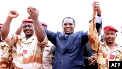 Le général du contingent tchadien au Mali Oumar Bikimo, à gauche, s'entretient avec le président du Tchad Idriss Deby Itno, au centre, et le commandant en second et son fils Mahamat lors d'une cérémonie de bienvenue, à N'Djamena, le 13 mai 2013. (AFP)