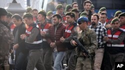 Paramilitary police escort the defendants as a trial opened in Mugla, southern Turkey, Monday, Feb. 20, 2017, for 47 people accused of attempting to kill President Recep Tayyip Erdogan on the night of the failed coup, while he was vacationing with his family.