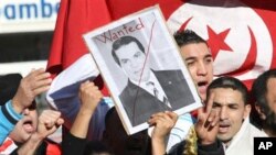 A woman holds a picture of Tunisia's deposed leader Zine El Abidine Ben Ali, reading "Wanted", during a demonstration showing solidarity with Tunisians, in Marseille, southern France , Jan. 15, 2011. Unrest engulfed Tunisia on Saturday after a popular reb