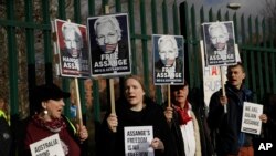 Pendukung Julian Assange memegang spanduk di luar Pengadilan Belmarsh Magistrates di tenggara London, 25 Februari 2020. (Foto: AP)