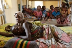 FILE - Woman and children, rescued by Nigerian soldiers from captivity by Boko Haram fighters, rest at a refugee camp in Yola, Nigeria, May 3, 2015.