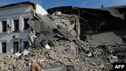 ຜູ້​ຊາຍ​ຄົນ​ນຶ່ງ​ນັ່ງ​ເບິ່ງ​ຕຶກ​ຫ້ອງ​ການ​ທີ່​ຖືກ​ທຳ​ລາຍ​ໂດຍ​ການ​ໂຈມ​ຕີ​ດ້ວຍ​ລູກ​ສອນ​ໄຟ​ໃນ​ນະ​ຄອນຫຼວງ ກີ​ຢິບ, 2 ກັນ​ຍາ, 2024.