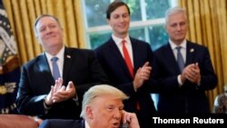 President Donald Trump is seen on the phone with leaders of Israel and Sudan in the Oval Office at the White House in Washington, Oct. 23, 2020.