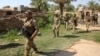 FILE - Iraq’s rapid response forces storm a house in the Tarmiyah district, north of Baghdad, searching for wanted Islamic State group suspects, July 21, 2019. Iraq declared victory against IS in 2017, but the group continues to attack with sleeper cells.