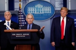 FILE - President Donald Trump and Vice President Mike Pence listen as Dr. Anthony Fauci, director of the National Institute of Allergy and Infectious Diseases, speaks about the coronavirus at the White House in Washington, April 17, 2020.